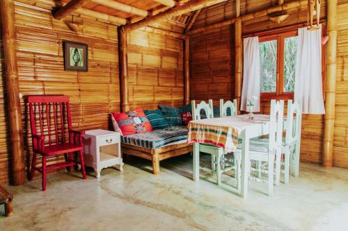 a dining room with a couch and a table and chairs at Designers Luxury Retreat with breathtaking gardens in Tzununá