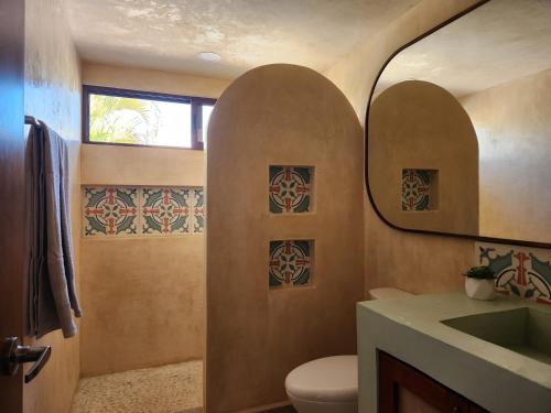 a bathroom with a toilet and a sink at Las Huayitas, by Casa Amaranto in Mérida