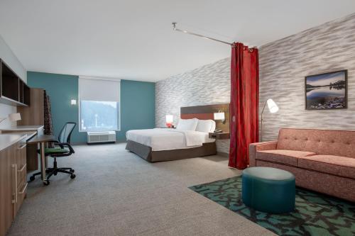 Habitación de hotel con cama y sofá en Home2 Suites By Hilton Calhoun, en Calhoun