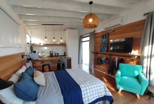 um quarto com uma cama e uma cadeira azul em Las Rochas, Suites de Mar em Punta Del Diablo