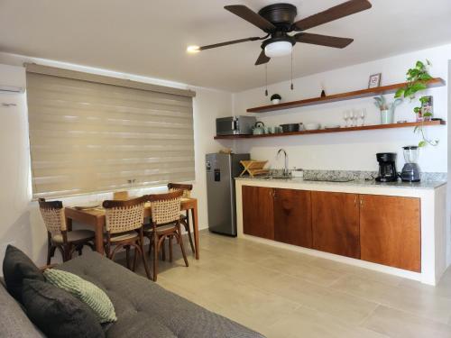 a kitchen and living room with a couch and a table at Comfortable private apartment AC near Montejo - Las Huayitas in Mérida