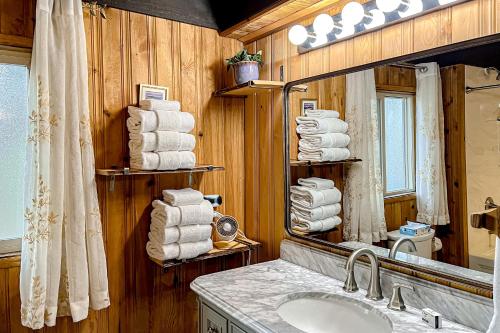 y baño con lavabo, espejo y toallas. en River Bend Chalet, en Sunriver