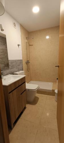 a bathroom with a sink and a toilet and a tub at Casa blanca in Santa Coloma de Gramanet