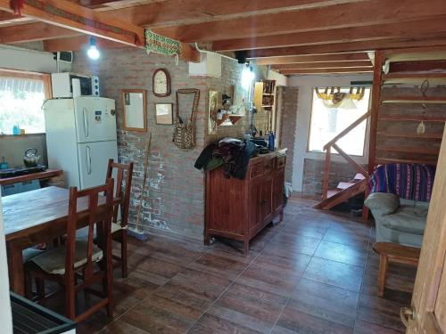 a kitchen with a refrigerator and a table and chairs at El Bungalow de Raúl in Epuyén