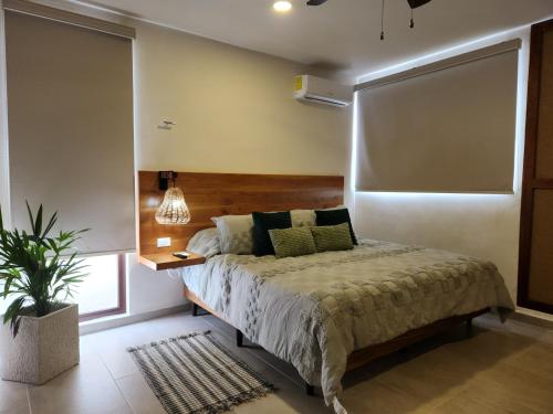 Las Huayitas, by Casa Amaranto في ميريدا: غرفة نوم مع سرير وزرع الفخار