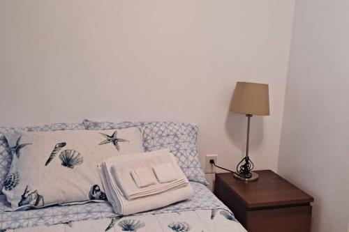 a bed with a pillow and a lamp on a table at Brand new studio apartment in Vero Beach