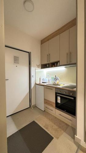 a small kitchen with a sink and a refrigerator at Apartman Sunce Bjelasnica in Bjelašnica