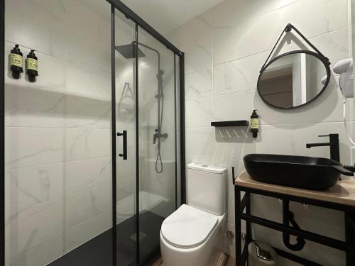 a bathroom with a shower and a toilet and a sink at CC Opera Suites in Madrid