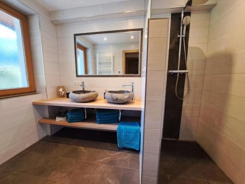 uma casa de banho com 2 lavatórios e um chuveiro em Apart Dahuam em Aschau
