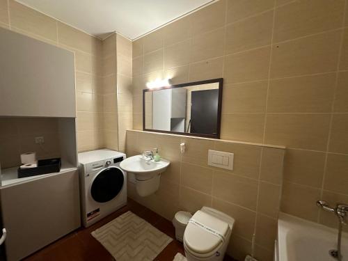 a bathroom with a toilet and a sink and a mirror at Apartament “La Iepure” in Braşov