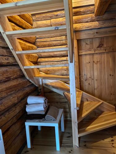 una escalera en una cabaña de madera con banco y toallas en Tiku puhketalu, en Kiidjärve