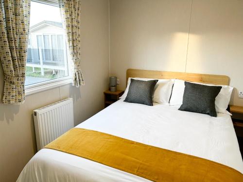 sypialnia z dużym łóżkiem i oknem w obiekcie Seaside Escape at Trecco Bay w mieście Porthcawl
