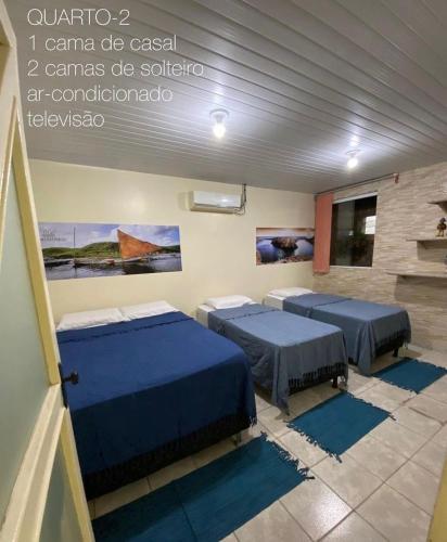 a room with three beds in a room at Aconchego de Maria in Piranhas