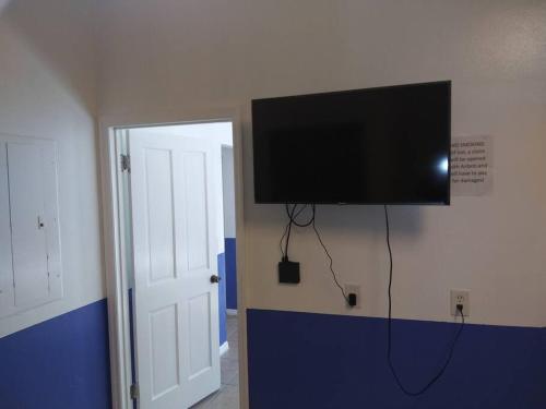 TV de pantalla plana colgada en la pared de una habitación en mini Apartment in sunshine city Florida, en Vero Beach