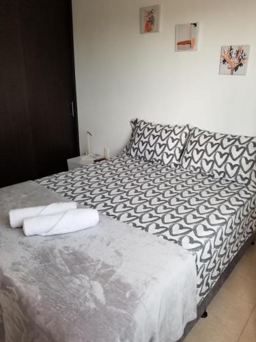 a bedroom with a bed with black and white sheets at APARTAESTUDIO en el Norte de Armenia, en la via a Salento y Filandia Con parqueadero de carro in Armenia