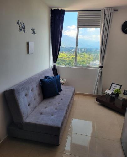 a living room with a couch and a large window at APARTAESTUDIO en el Norte de Armenia, en la via a Salento y Filandia Con parqueadero de carro in Armenia