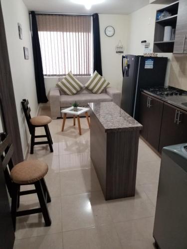 a kitchen and living room with a couch and a table at APARTAESTUDIO en el Norte de Armenia, en la via a Salento y Filandia Con parqueadero de carro in Armenia