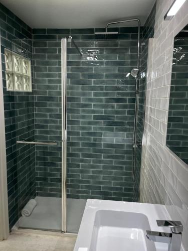 un bagno con doccia e lavandino bianco di Exyca Tetuán a Madrid