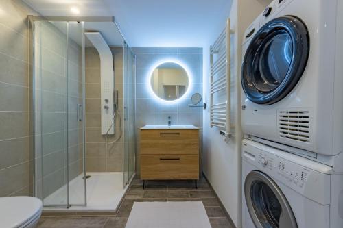 une salle de bain avec une machine à laver et un lave-linge dans l'établissement Le bel appart Toulouse climatisation, à Toulouse