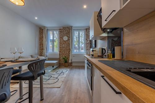 une cuisine avec un comptoir et une salle à manger dans l'établissement Le bel appart Toulouse climatisation, à Toulouse