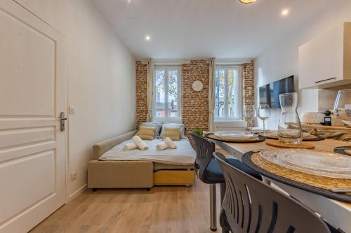 un salon avec une table et un canapé dans l'établissement Le bel appart Toulouse climatisation, à Toulouse