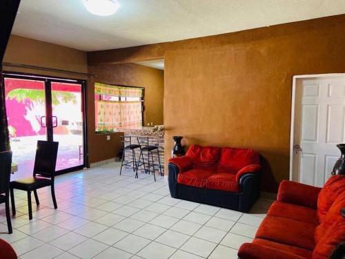 a living room with a red couch and a table at Casa El Pescador in Mulegé