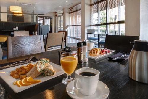 a table with a plate of food and a glass of orange juice at Holiday Inn Detroit Metro Airport by IHG in Romulus