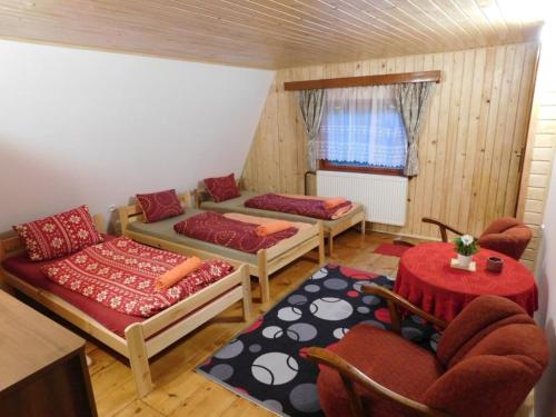a living room with two beds and a table at Chata na Čertove in Štôla