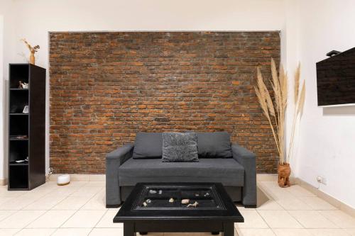 a living room with a couch and a brick wall at Ideal 3 ambientes c/ homeoffice. Palermo-V.Crespo in Buenos Aires