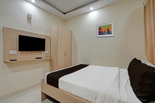 a bedroom with a bed and a flat screen tv at Collection O Cka Boarding And Lodging in Yelahanka