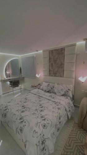 a bedroom with a large bed and a desk at استديو مع جلسة خارجية بدخول ذكي in Riyadh