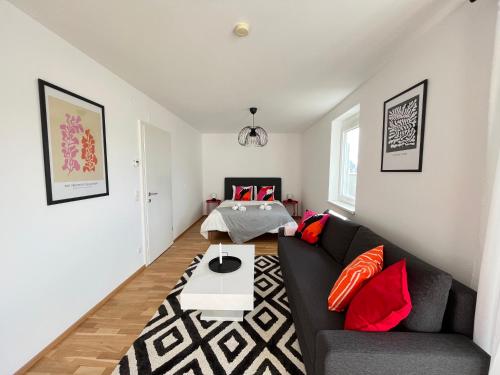 - un salon avec un canapé noir et des oreillers rouges dans l'établissement Penthouse near Central Station with free parking, à Vienne