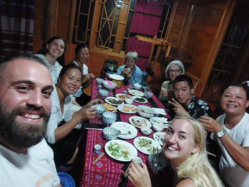a group of people sitting around a table eating food at Muong Hoa Hmong Homestay in Sapa