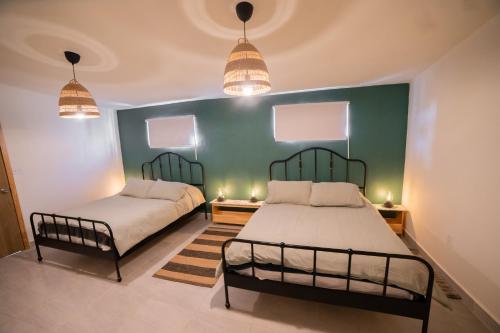 um quarto com duas camas e duas luzes na parede em CASA MARES - Beach and Sun em Ensenada