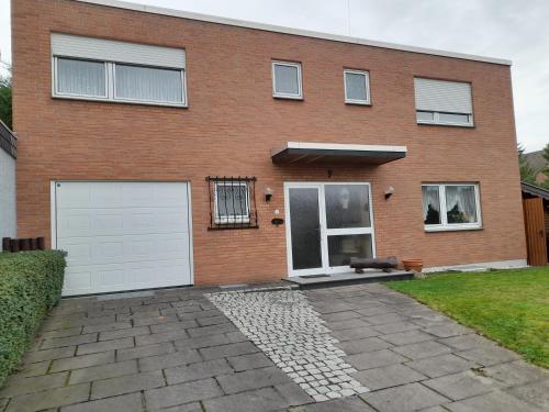 a brick house with two white garage doors at Ferienwohnung Aue Deußen in Erftstadt