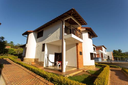 a white house with a balcony and a patio at Condominio Parque Baviera in Barichara