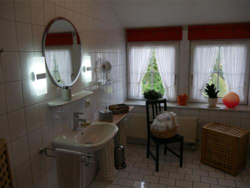 La salle de bains est pourvue d'un lavabo et d'un miroir. dans l'établissement Ferienwohnung Backbord, à Werdum