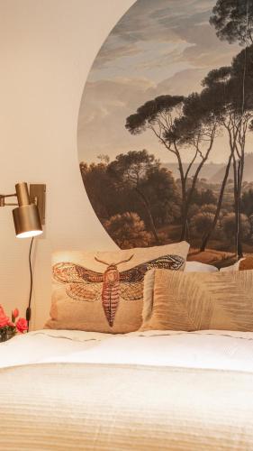 a bedroom with a bed with a painting on the wall at Stayatsas Tiny House Julia in de bossen op de Veluwe! in Epe