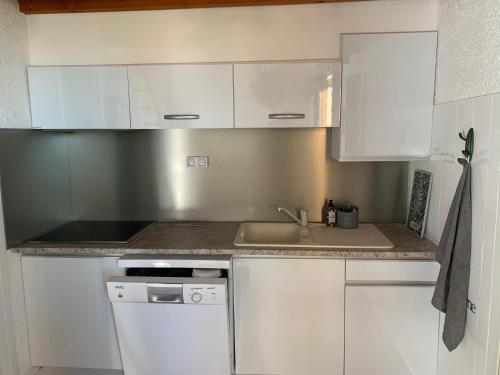 a kitchen with white cabinets and a sink at T3 à port leucate climatisé 50m de la plage in Port Leucate