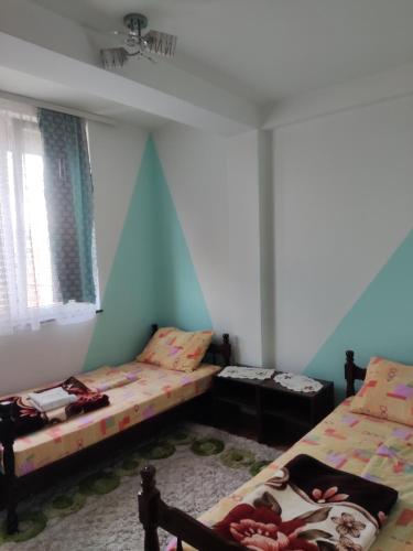 2 camas en una habitación con paredes azules en Kralj en Prokuplje