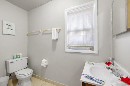 a bathroom with a toilet and a sink and a window at Modern Posh Upenndrexel Univ 3 Bdrm in Philadelphia