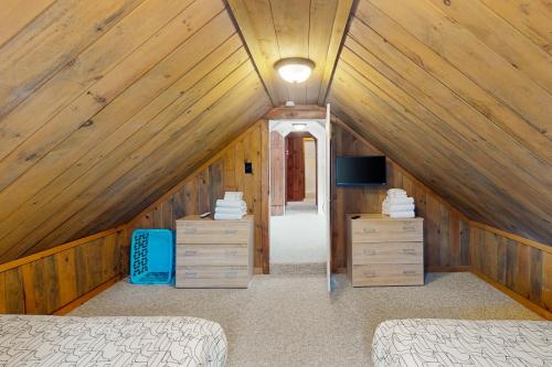 a attic bedroom with two beds and a tv at Jay Peak Getaway on Trout River in Montgomery