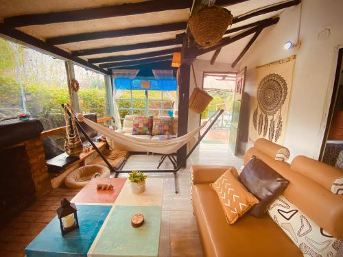 sala de estar con sofá y hamaca en Cabaña del Vitruvio cerca termales de Paipa en Paipa