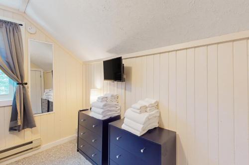 a room with a pile of towels and a mirror at Jay Peak Getaway on Trout River in Montgomery