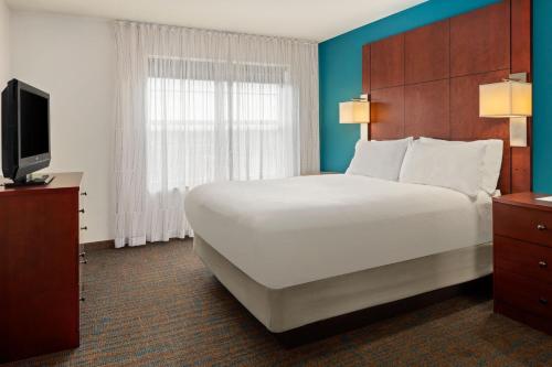 a hotel room with a large bed and a television at Residence Inn Minneapolis Plymouth in Plymouth