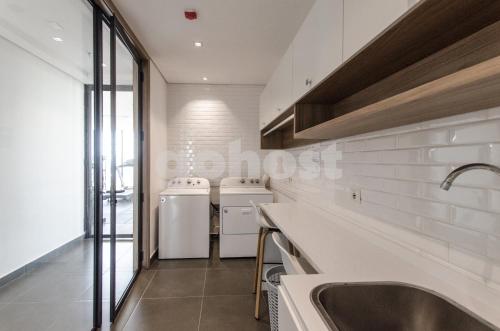 cocina con electrodomésticos blancos y fregadero en Luxurious And Dazzling Villa Morra Apartment, en Asunción