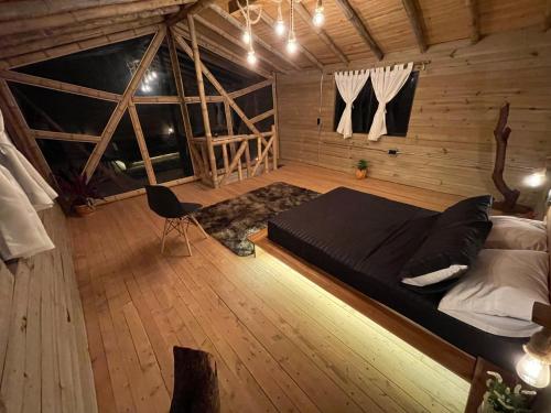 麥德林的住宿－Bamboo Lodge, vista privilegiada a las montañas，木制客房内的一间卧室配有一张大床