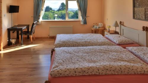 a bedroom with two beds and a desk and a piano at Connemara Haven Bed and Breakfast in Oughterard