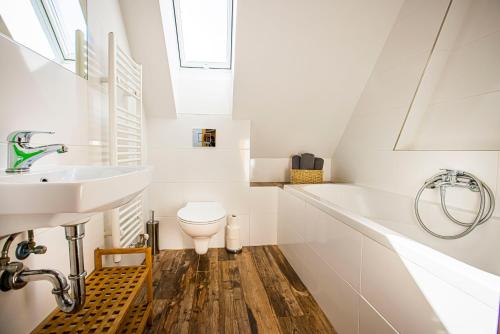 a white bathroom with a sink and a toilet at Holiday Home Holiday Raj in Bešeňová