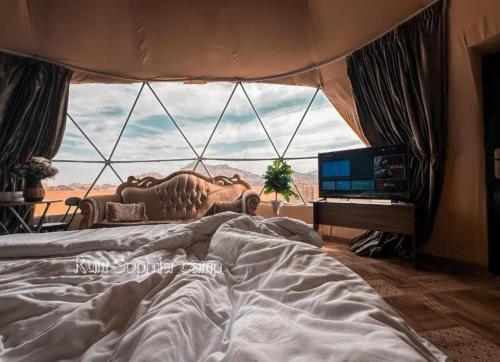 - une chambre avec un lit et une grande fenêtre dans l'établissement Maestro camp Wadi Rum, à Wadi Rum